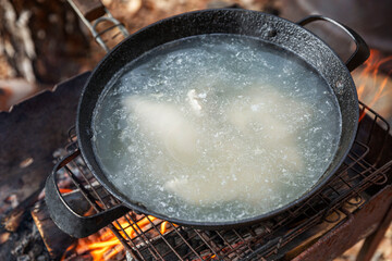 Appetizing broth in a large pan with pieces of chicken. Healthy food and traditional dish. Close-up.