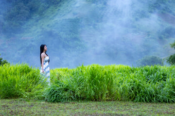 Asian woman smiles happily and standing in the natural surrounded. Beautiful woman relax in the...