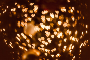 Blurred hearts golden lights on a black background