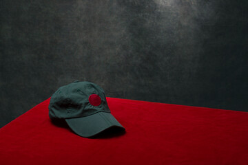 A green cap on the table with a red tablecloth