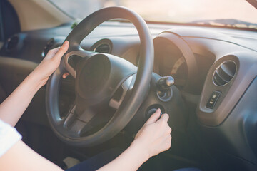 Hands holding steering wheel in car