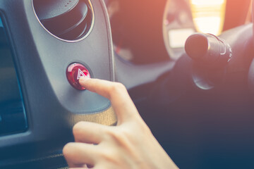 Finger hitting car emergency red light button in the car. - obrazy, fototapety, plakaty
