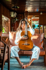 woman okaying posing with guitar in restaurant cafe