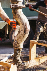 Construction worker pours concrete on rebar using concrete pump