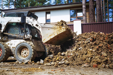 Front loader dumping stone and sand