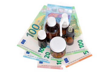 Different Bottles with Pills, Capsules and Medicines on the Euro Banknotes - Isolated on White. Global Pharmaceutical Industry and Big Pharma. Euro Money Bills - Isolation