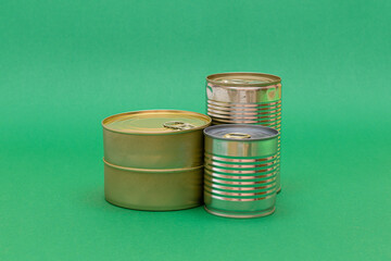 A Group of Stacked Tin Cans with Blank Edges on Green Background. Canned Food. Different Aluminum Cans for Safe and Long Term Storage of Food. Steel Sealed Food Storage Containers