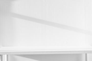 Empty white desk with morning light and shadows of windows with copy space, summer concert. Blurred backdrop abstract background for display product.