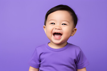 Portrait of a cute Asian American baby boy wearing purple tee shirt laughing on purple background - obrazy, fototapety, plakaty
