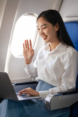 Hand wave, video call on laptop computer, Thoughtful asian people female person onboard, airplane window, perfectly capture the anticipation and excitement of holiday travel. chinese, japanese people