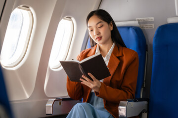 using note book, Elegantly dressed brown suit Asian chinese japanese people businesswoman immersed...