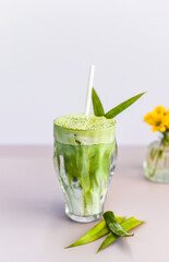 blended brew matcha latte with straw on light gray background