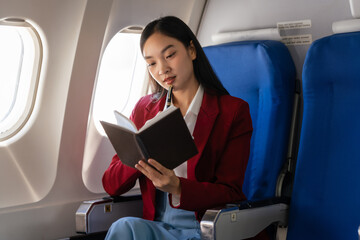 Passionate female asian chinese japanese people student aboard airplane, clutching textbooks,...