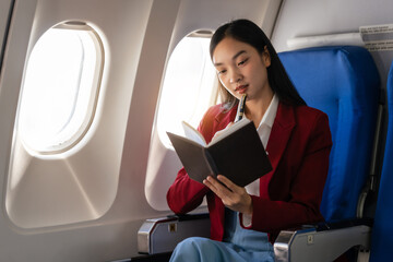 Passionate female asian chinese japanese people student aboard airplane, clutching textbooks,...