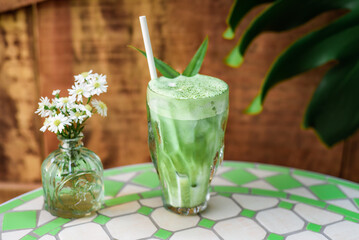 blended brew matcha latte with straw on light gray background