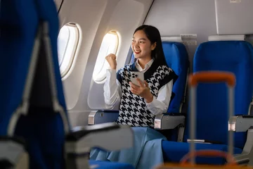 Foto op Plexiglas Passionate female asian chinese japanese people student aboard airplane, clutching textbooks, eagerly anticipating her overseas academic venture. © Ratirath