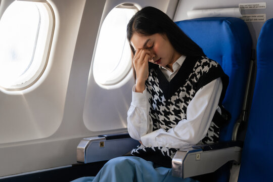 Female asian chinese japanese people passenger experiencing airsickness, clenching sick bag and looking uneasy mid-air.