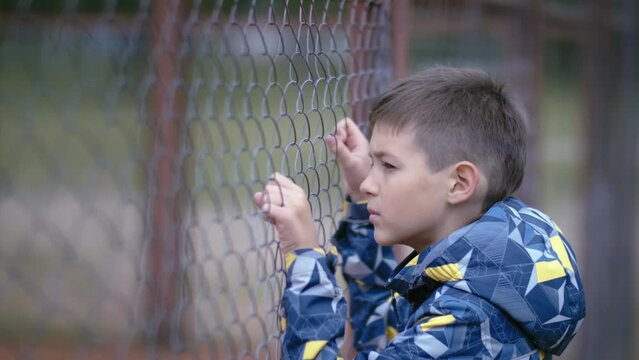 Contemplative Youth: Boy Reflecting by the Fence, Deep in Thought