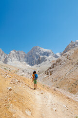 child travels in the mountains with a backpack. mountain hike in high mountains. Turkey.