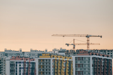 Fototapeta na wymiar Cranes and building with evening sky background