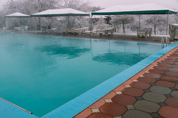 Swimming pool with hot mineral water in winter. Thermal water for the treatment of diseases of the musculoskeletal system. Rehabilitation after illnesses in an open-air swimming pool.