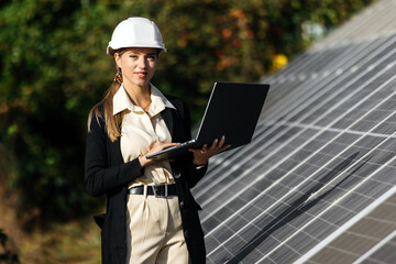 Solar panels and investor with laptop. Business woman with laptop near solar panels. Green energy for home and business