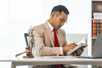 Middle-aged Asian indian people male lawyer meticulously reviews legal documents. Courtroom judge...