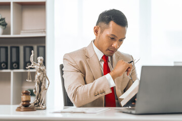 Middle-aged Asian indian people male lawyer meticulously reviews legal documents. Courtroom judge...