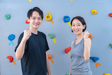 Fototapeta premium クライミングウォールの前でポーズをとる2人
