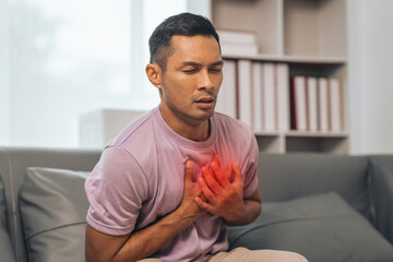 Middle-aged Asian Indian man with Heart disease, sitting on sofas