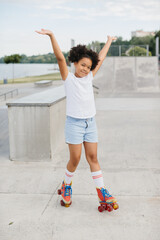 Cute teenage girl riding on roller skate in summer park. Funny girl playing on roller skate...