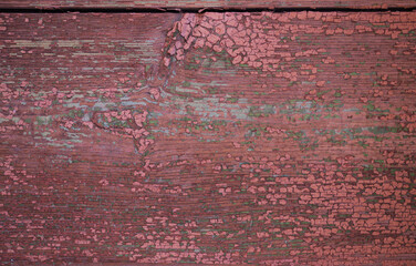 Weathered red wooden surface with peeling paint and texture details