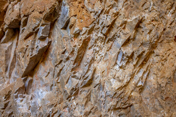 Natural rock texture background. Rocky bas-relief wall.