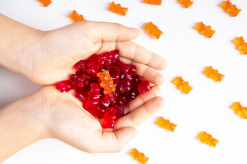 Vitamins and supplements gummy bears  in child hands on a white background. medicine concept....