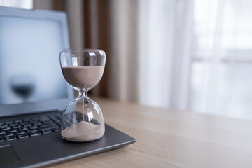 Hourglass on the table for business deadline. Time concept