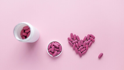 Vitamins for womens health. Mental health concept. pink packground. Heart with pills