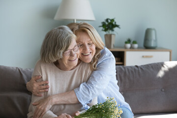 Happy loving mature daughter woman hugging old 80s mom with warmth, affection, devotion, visiting...