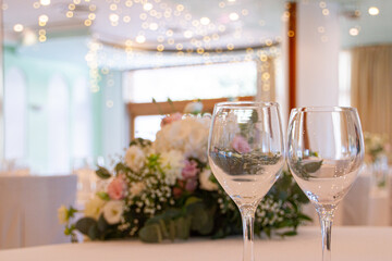 Detail of two glass cups in an environment decorated with flowers.