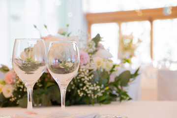 Detail of two glass cups in an environment decorated with flowers.