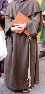 Franciscan friar with the brown dress called habit and the rope around his waist with the sacred book on hand