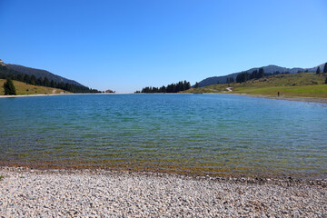 artificial lake used as a water reserve to make snow on the ski slopes in winter in the mountains - obrazy, fototapety, plakaty