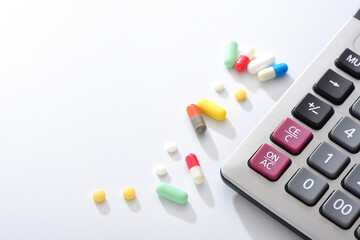 A pile of drugs placed next to the calculator on a white background