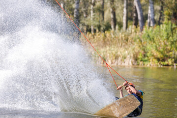 Sportsman on wakeboard falling after a trick on his back