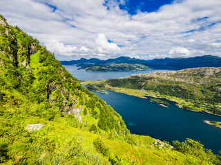 Naklejka na ściany i meble Tranquil Norwegian Mountain Landscape Overlooking Meadow and Sea
