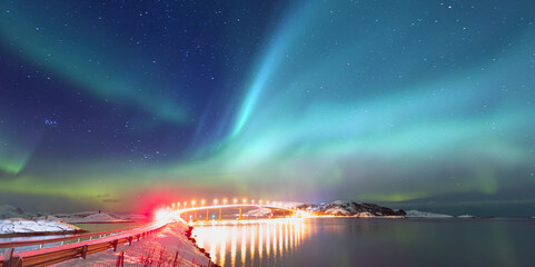 Sommaroy Bridge is a cantilever bridge connecting the islands of Kvaloya and Sommaroy with Aurora Borealis - Hillesoy Tromso Norway