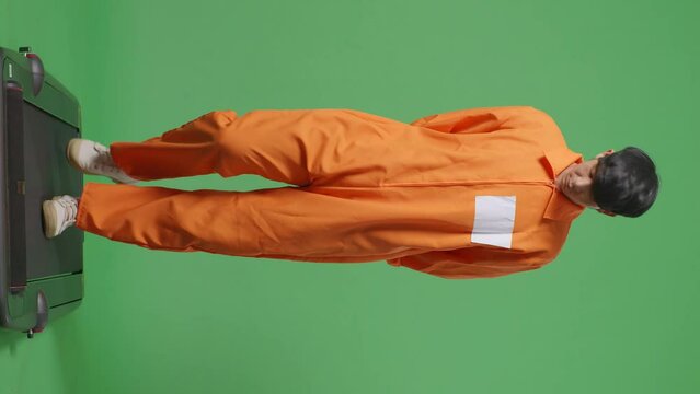 Full Body Of Asian Male Prisoner In Handcuffs Walking On The Green Screen Background
