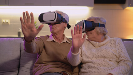 A retired couple is wearing VR goggles and exploring space in a virtual reality simulation