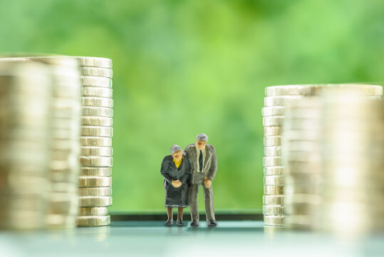 Pension insurance for retirees and social security tax, financial concept : Senior or elder retired couple stands among stacks of coins, depicting a long-term investment strategy for an aging society.