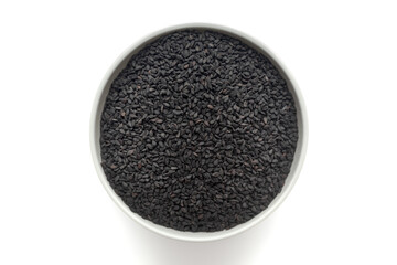 Black organic Sesame (Sesamum indicum) seeds in a white ceramic bowl. Isolated on a white background. Top View