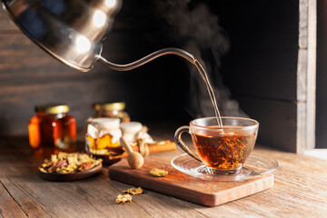 Make a cup of hot tea or a glass of chrysanthemum tea. and chrysanthemums lay on the wooden table Pouring healthy drinks, herbal drinks and medical concept - obrazy, fototapety, plakaty